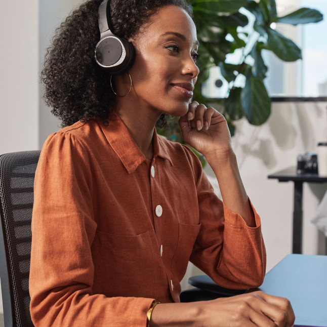 Person in a headset focuses intently on a video meeting.