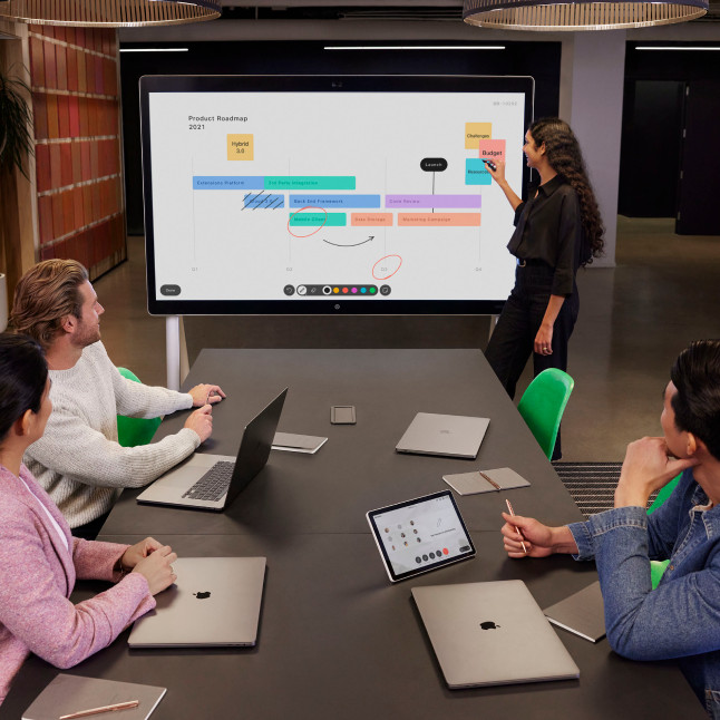 Team having a conference with laptops and digital whiteboard