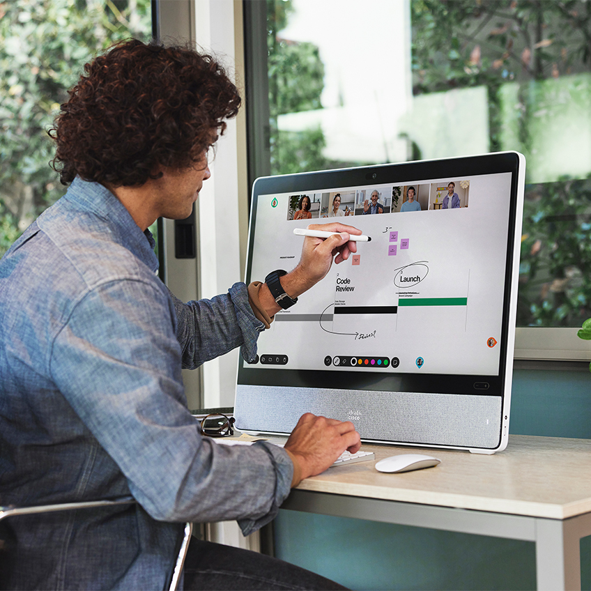 Employee uses stylus to whiteboard on Cisco Desk.